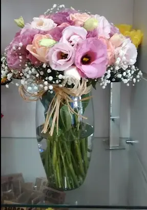 Arranjo floral em vaso de vidro com flores em tons de rosa