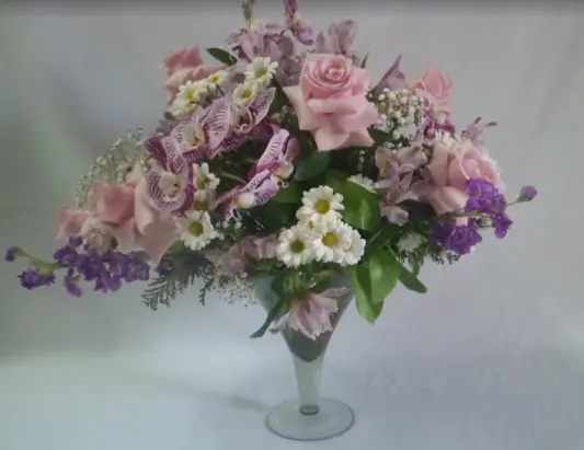 Vaso de flores com rosas, orquídeas e flores do campo